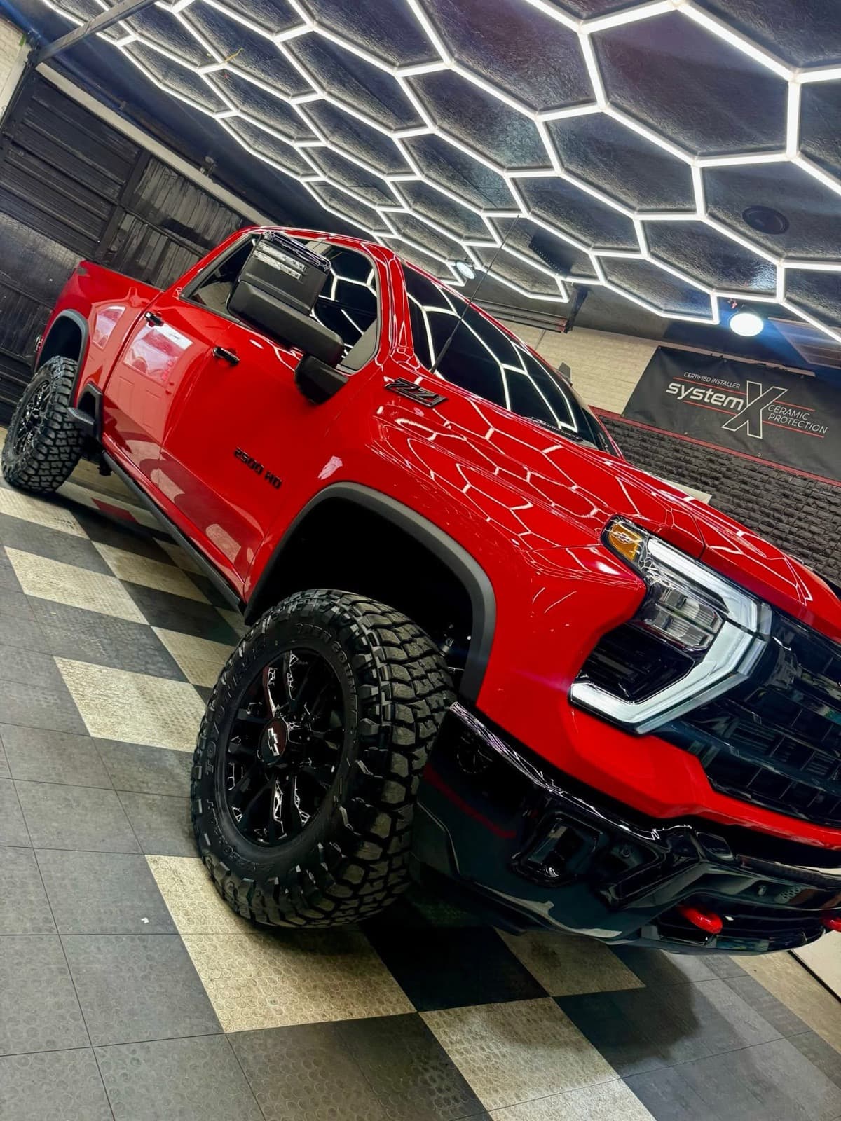 Ceramic-coated red Chevrolet 2500HD Z71 with hexagon-lit reflection — CTR Pro Coat ceramic coating in Lockport, LA