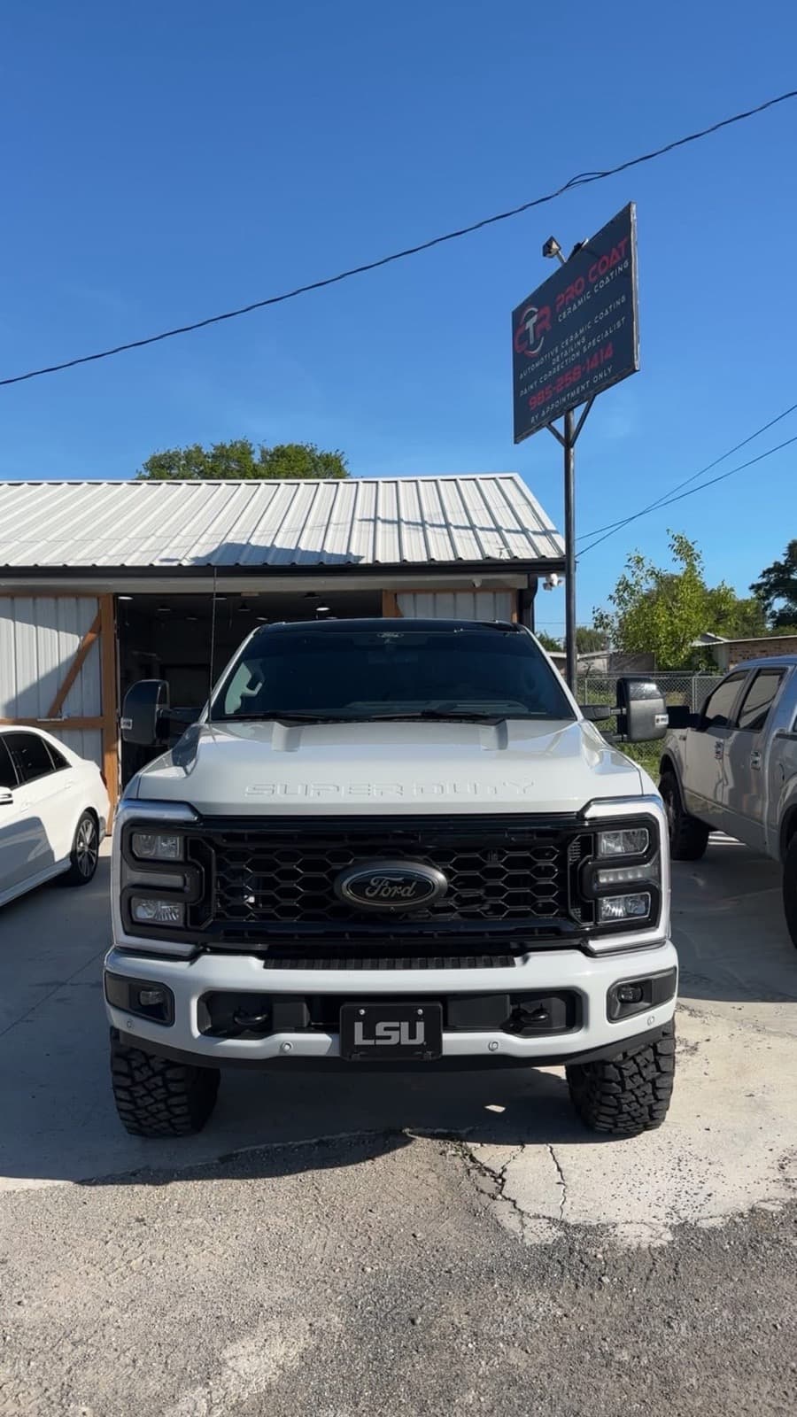 Ceramic-coated white Ford F-250 Super Duty in front of the CTR Pro Coat ceramic coating sign in Lockport, LA