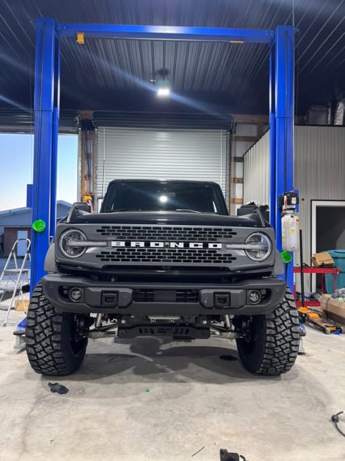 Lifted Ford Bronco on the lift inside the Elite Custom Automotive shop in Lockport, LA