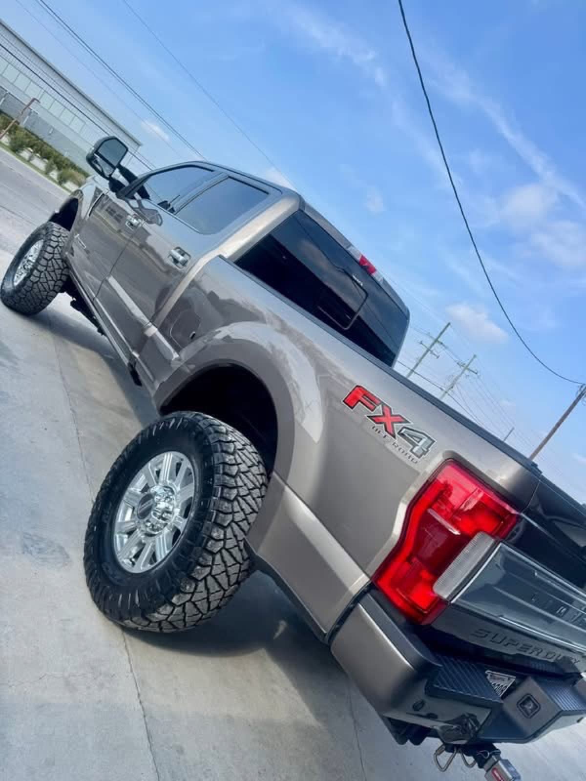 Lifted bronze Ford F-250 Super Duty FX4 with mud-terrain tires built by Elite Custom Automotive in Lockport, LA