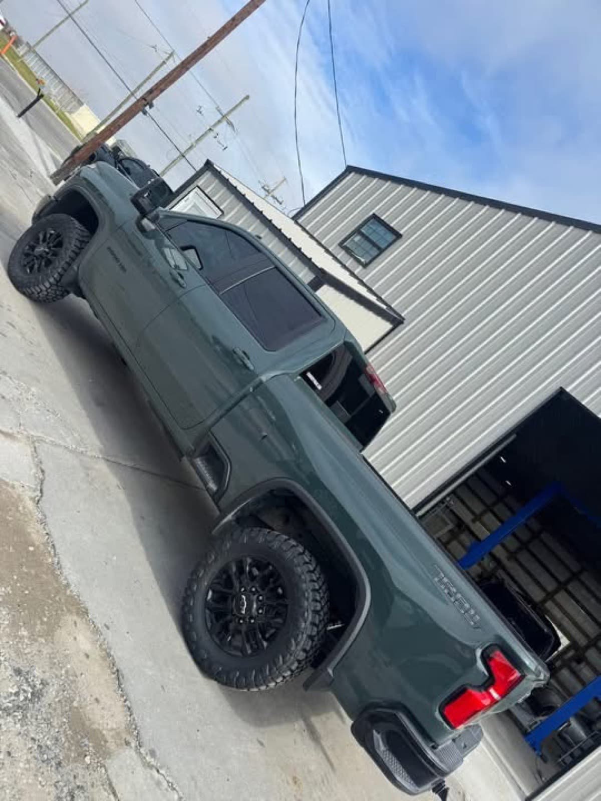 Lifted dark green Toyota Tundra TRD on black wheels at the Elite Custom Automotive shop in Lockport, LA